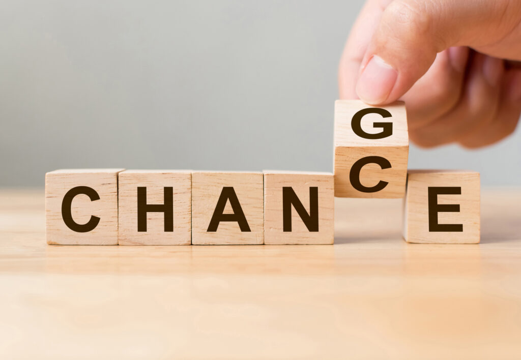 Hand flip wooden cube with word "change" to "chance",